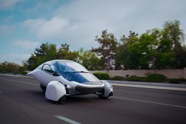 A futuristic, aerodynamic vehicle design with a sleek silver body and distinctive wheel coverings.