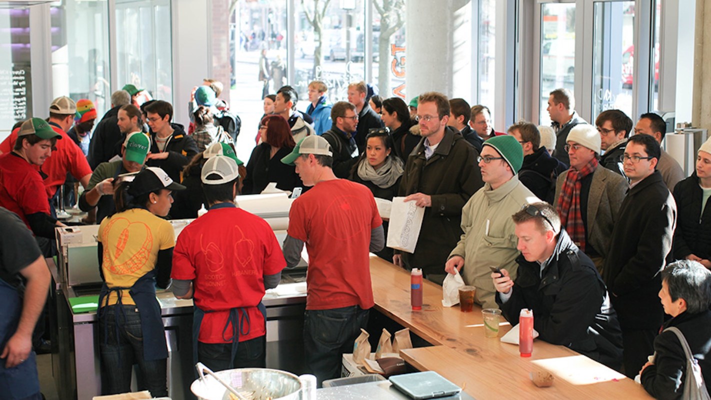 A bustling restaurant with customers and staff dressed casually.