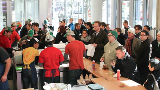 A bustling restaurant with customers and staff dressed casually.