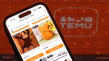 A smartphone displaying the Temu app with discounted items and a blurred keyboard in the background.