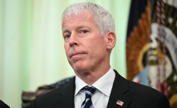 A man with gray hair and a serious expression, U.S. Secretary of Energy Chris Wright, stands in front of a presidential seal.