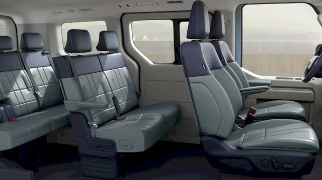 Interior view of a spacious three-row vehicle featuring modern seating with a mix of gray tones and ample headroom.