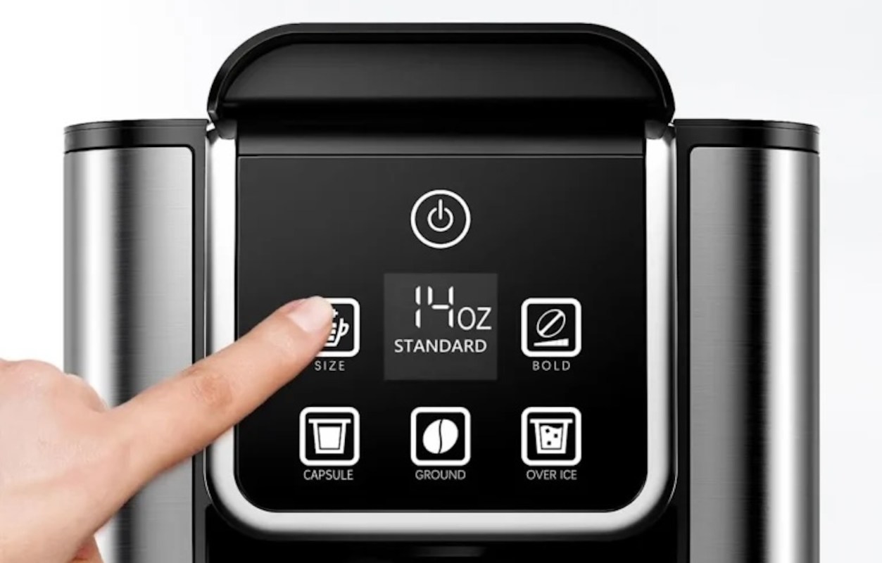 A hand pressing a button to select coffee size on a Kidisle control panel.