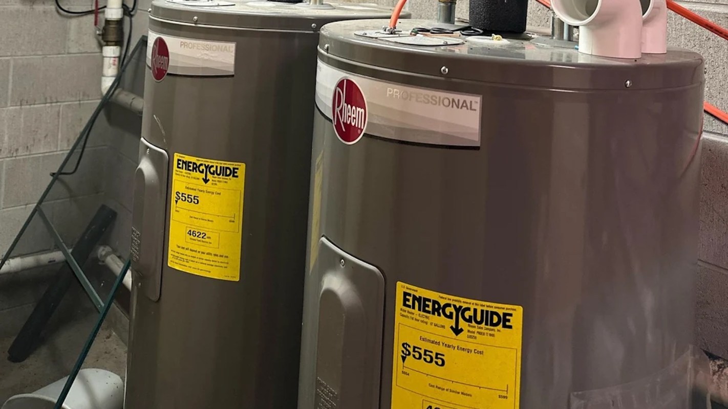 Two Rheem water heaters displayed side by side, each with an EnergyGuide label showing estimated yearly costs.