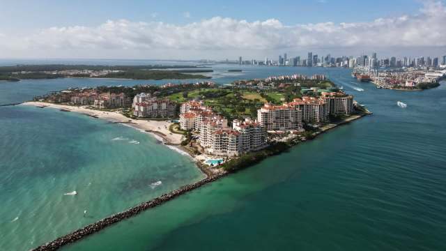 Aerial view of a wealthy residential island in front of the Miami skyline.