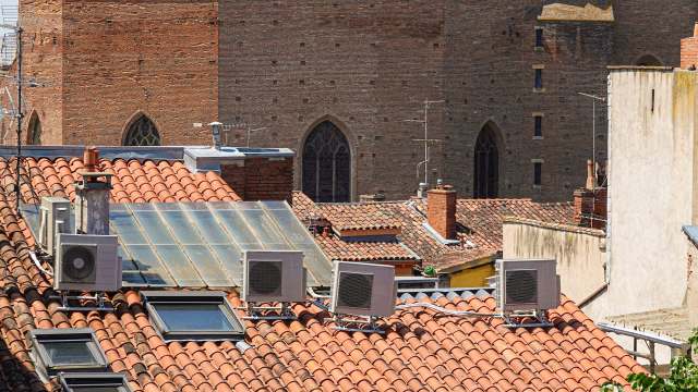 A rooftop view showing terracotta tiles and air conditioning units.