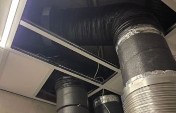 Exposed HVAC ductwork and ventilation pipes going through the ceiling.