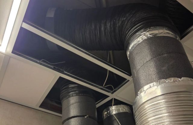 Exposed HVAC ductwork and ventilation pipes going through the ceiling.