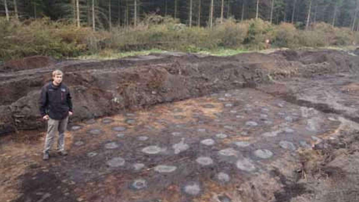 A person stands next to Iron Age hole belts.