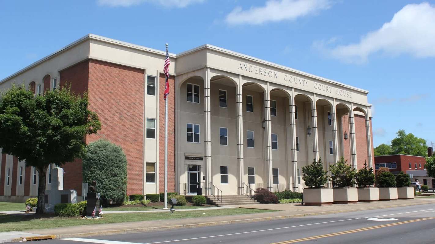 Anderson County Courthouse features a modern design with columns, flags, and landscaped gardens in front.