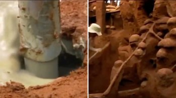 A close-up of a drilling pipe extracting slurry next to figures formed from earth.