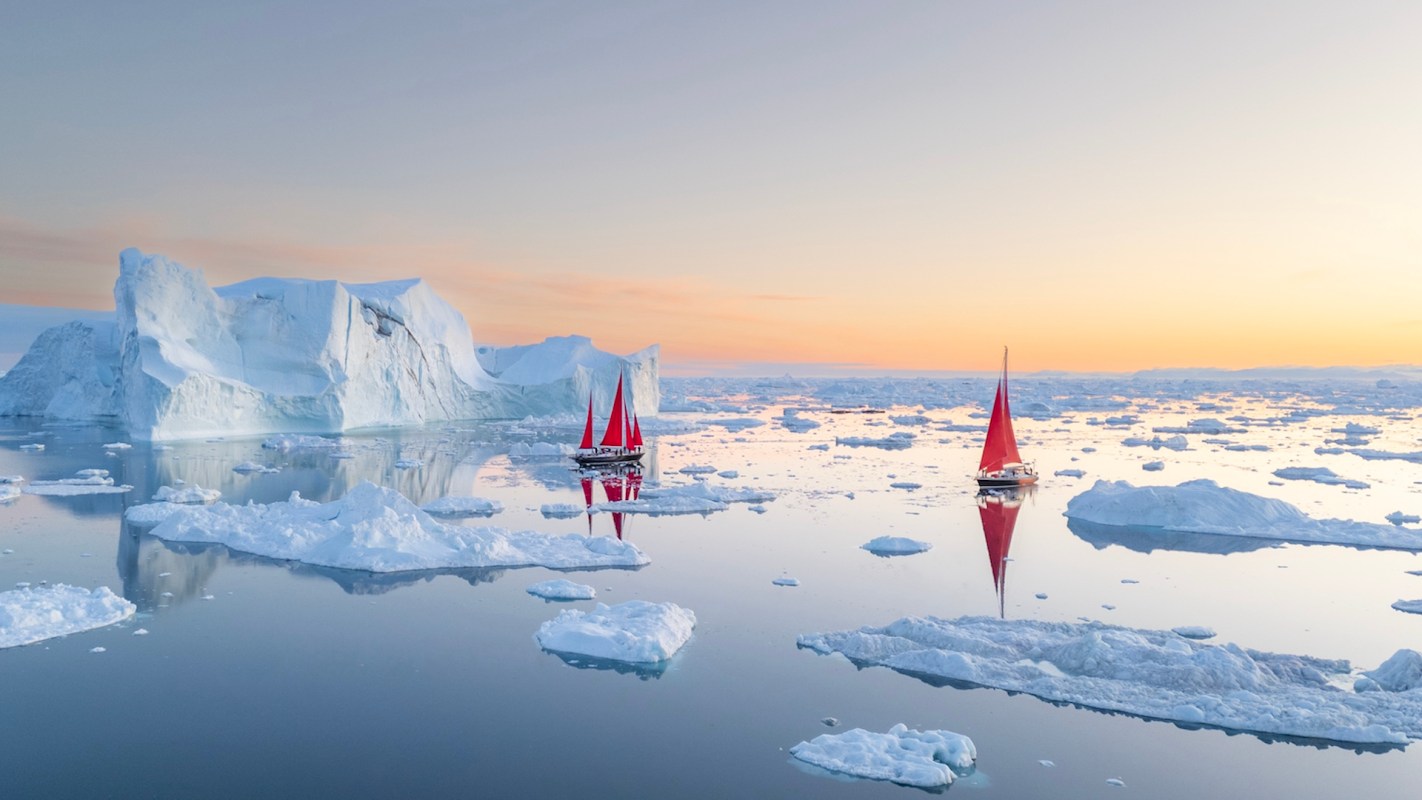 Two boats near small pieces of floating ice.