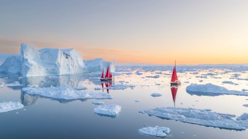 Two boats near small pieces of floating ice.