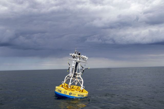A buoy with scientific instruments floats in the ocean.