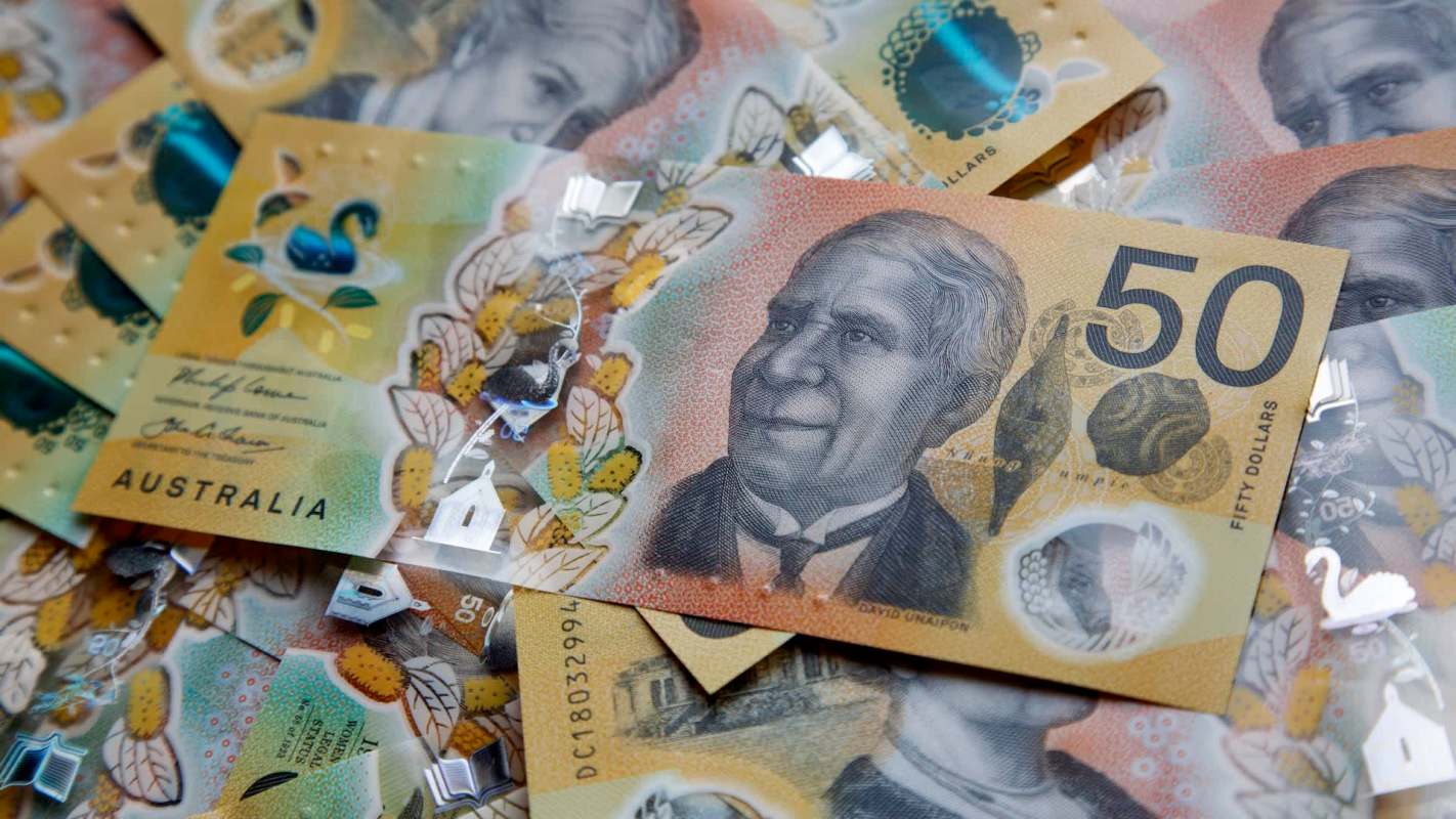 A close-up view of Australian fifty-dollar banknotes featuring intricate designs and a portrait.