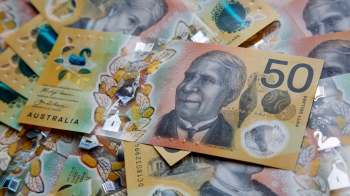 A close-up view of Australian fifty-dollar banknotes featuring intricate designs and a portrait.