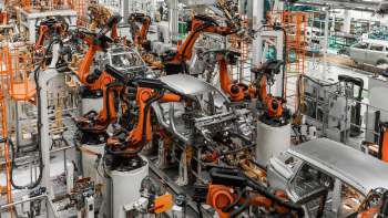 An automotive assembly line featuring multiple robotic arms assembling vehicle frames.