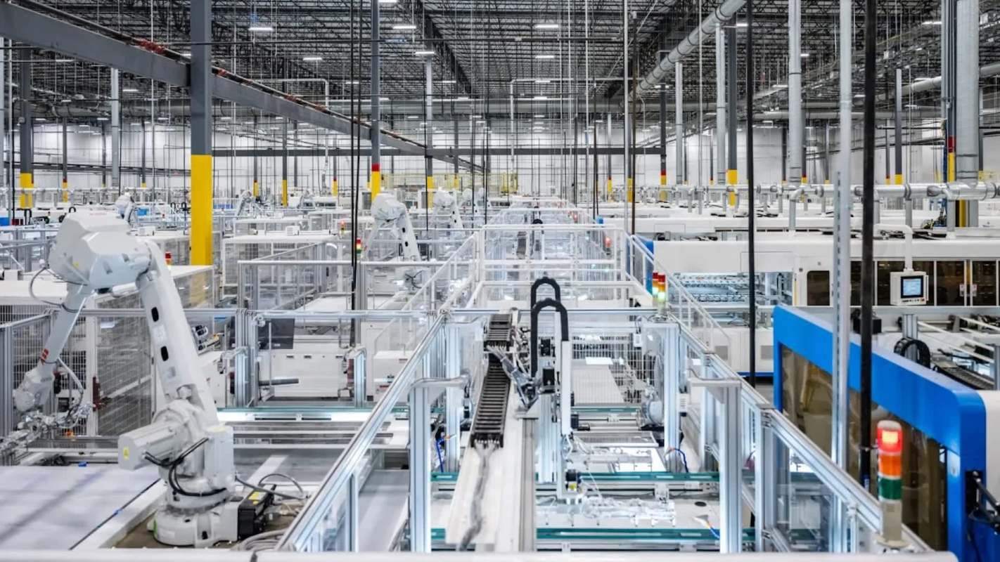 A modern automated factory interior with robotic arms and conveyor systems arranged in a spacious layout.