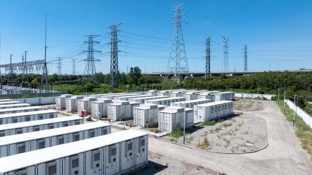 Rows of white battery energy storage systems in an industrial area.