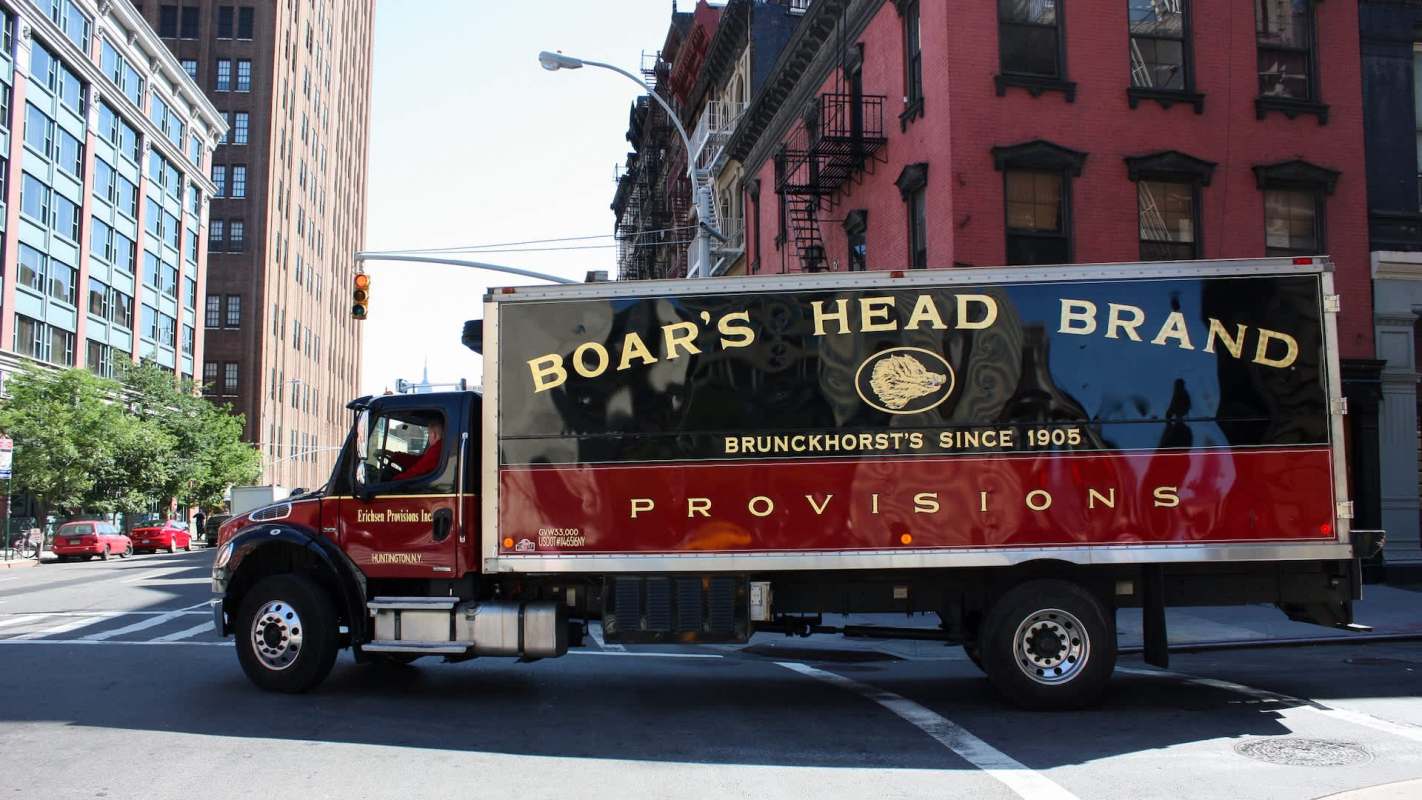 A delivery truck for Boar's Head Brand on a city street.
