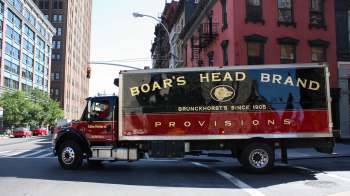 A delivery truck for Boar's Head Brand on a city street.