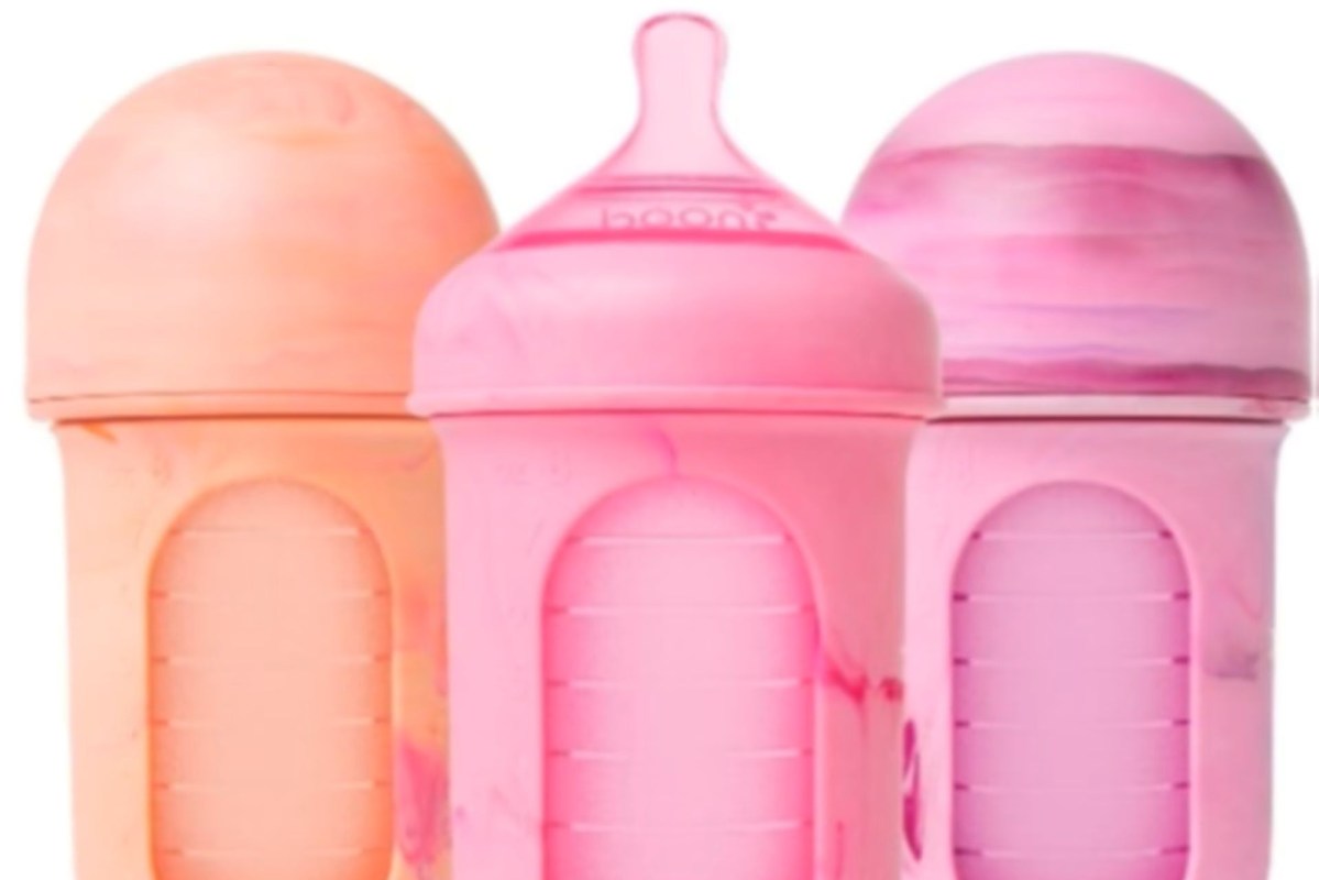Three baby bottles, in shades of pink and orange with marbled patterns.