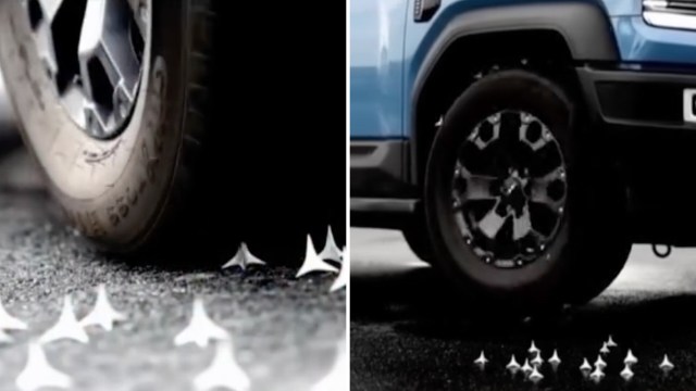 An SUV's tire rolling over spikes on the road.