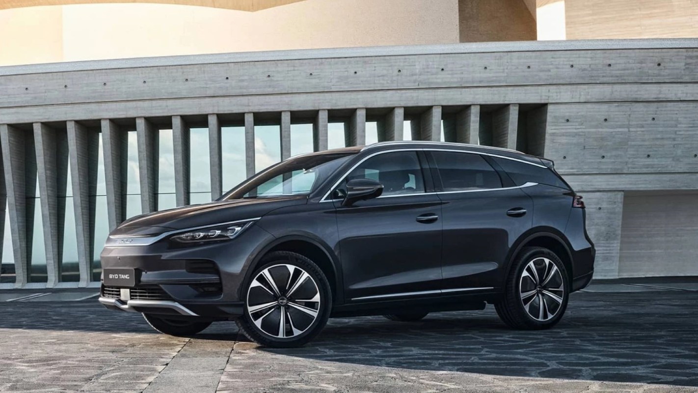 A black BYD Great Tang SUV parked in front of a modern building.