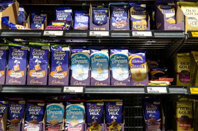 A shelf filled with various Cadbury chocolate bars, including Dairy Milk and Dream varieties.