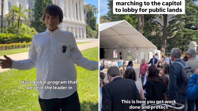 A smiling young man in a white shirt gestures outside a government building, surrounded by people at a rally.