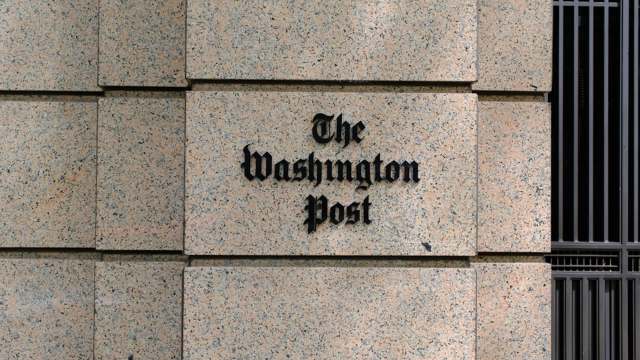 The exterior wall of a building features the sign for "The Washington Post" in bold lettering.