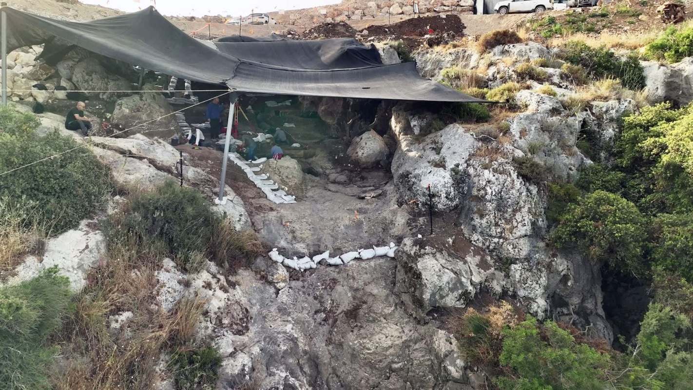 An excavation site amid vegetation on a rocky hillside.