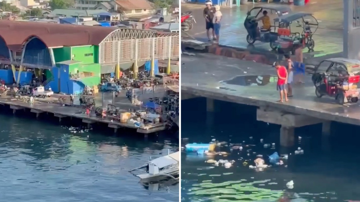 A bustling dock area with people, vehicles, and debris scattered in the water below.