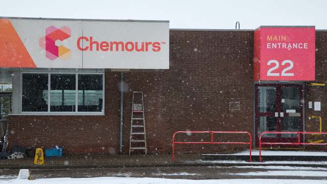 A snowy scene featuring the entrance of a building with a Chemours sign and a red main entrance marker.