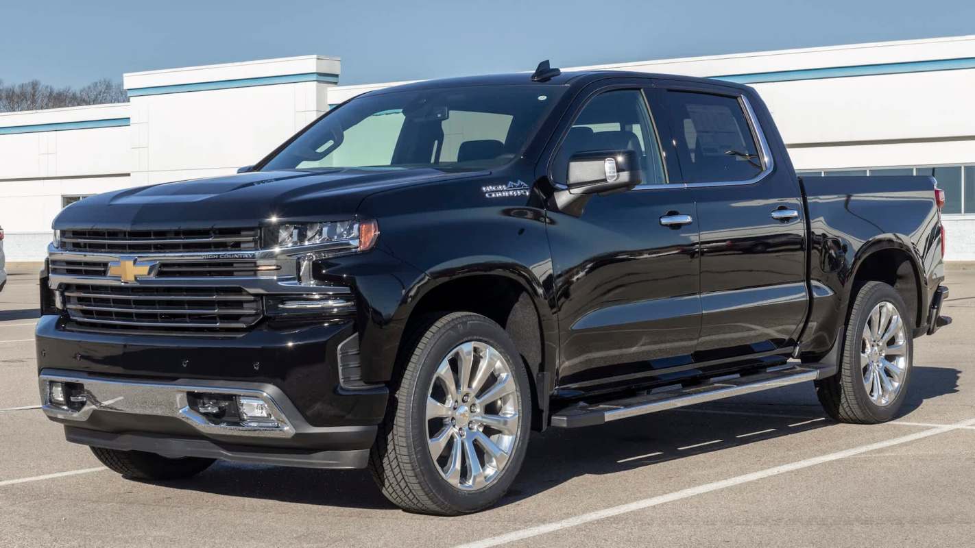 A black Chevrolet pickup truck parked in a lot under clear blue skies.