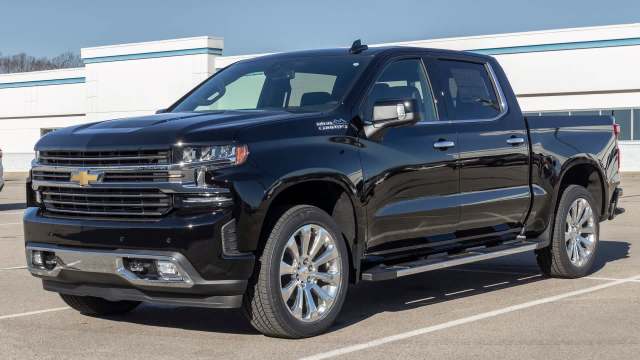 A black Chevrolet pickup truck parked in a lot under clear blue skies.