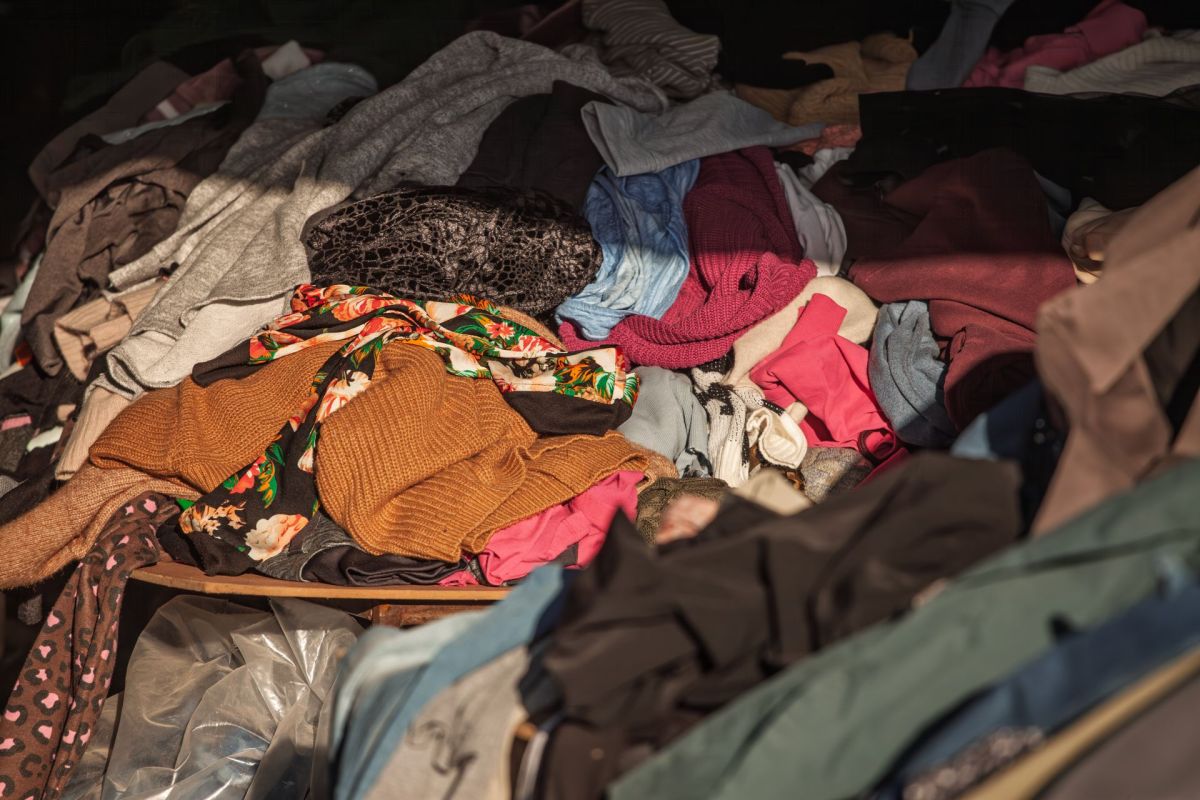 A messy pile of assorted clothing items in various colors and textures stacked together.