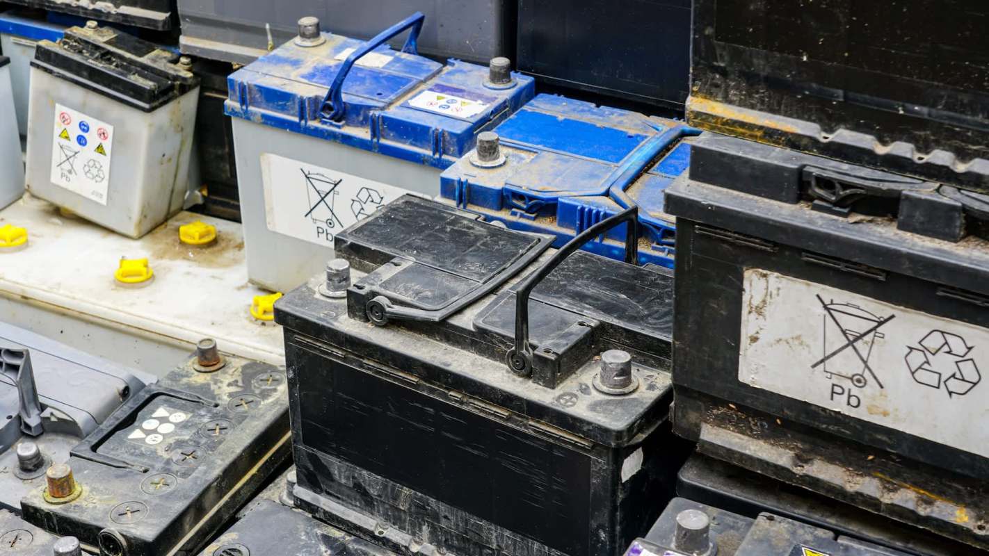 A collection of used batteries covered in dust.