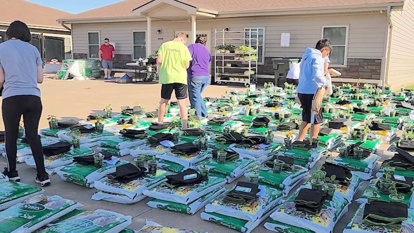 People sorting soil and plants for gardening.