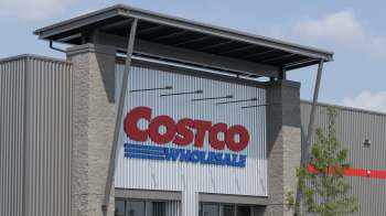 A close-up of a Costco Wholesale store sign mounted on a modern building facade.
