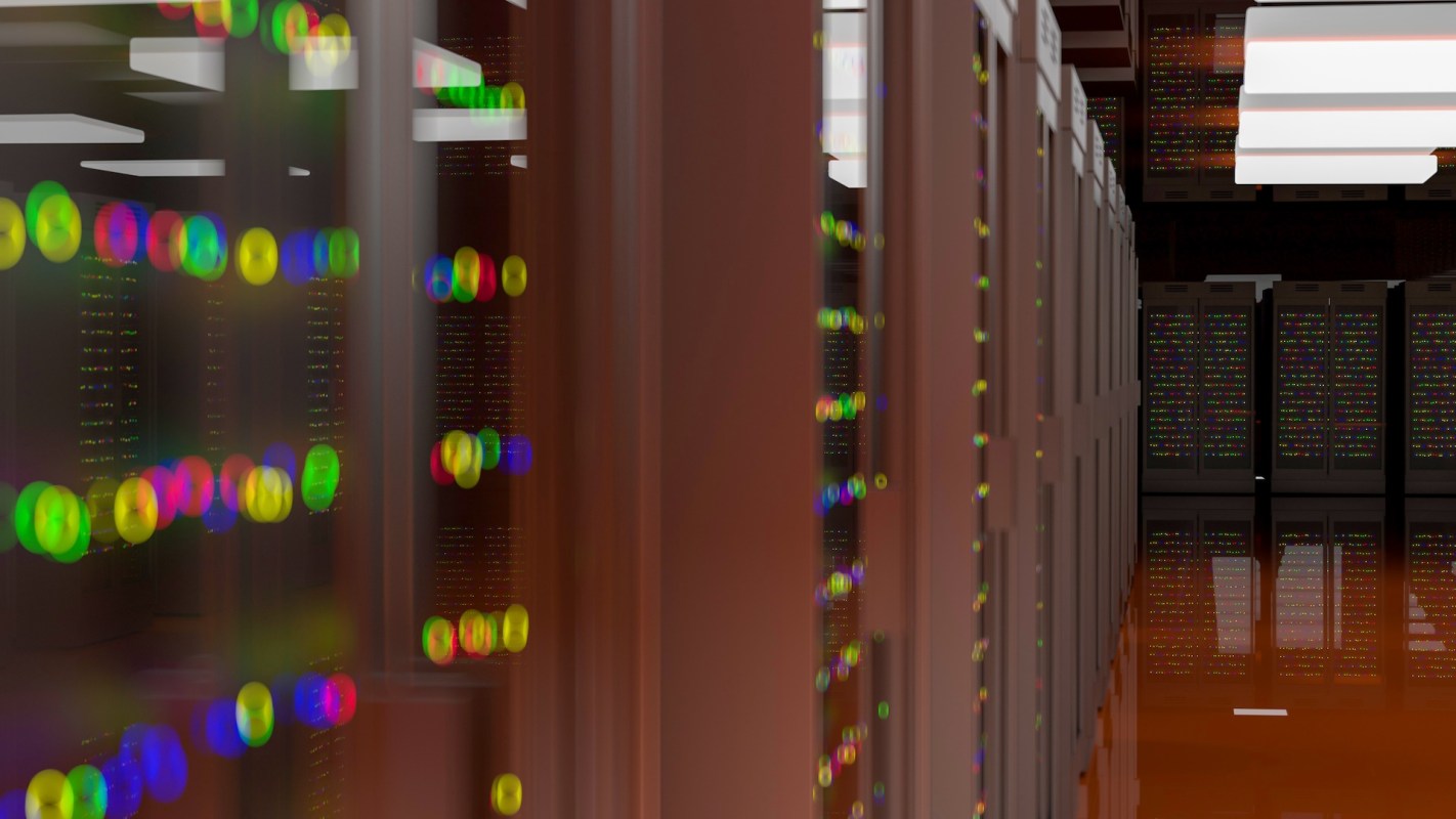 A corridor of server racks illuminated by colorful blinking lights in a data center.