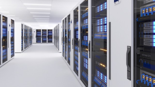 A corridor of a modern data center lined with server racks illuminated by blue LED lights.