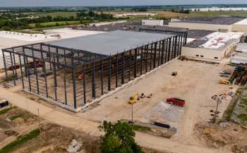 An aerial view of an industrial building under construction with heavy machinery and equipment on site.