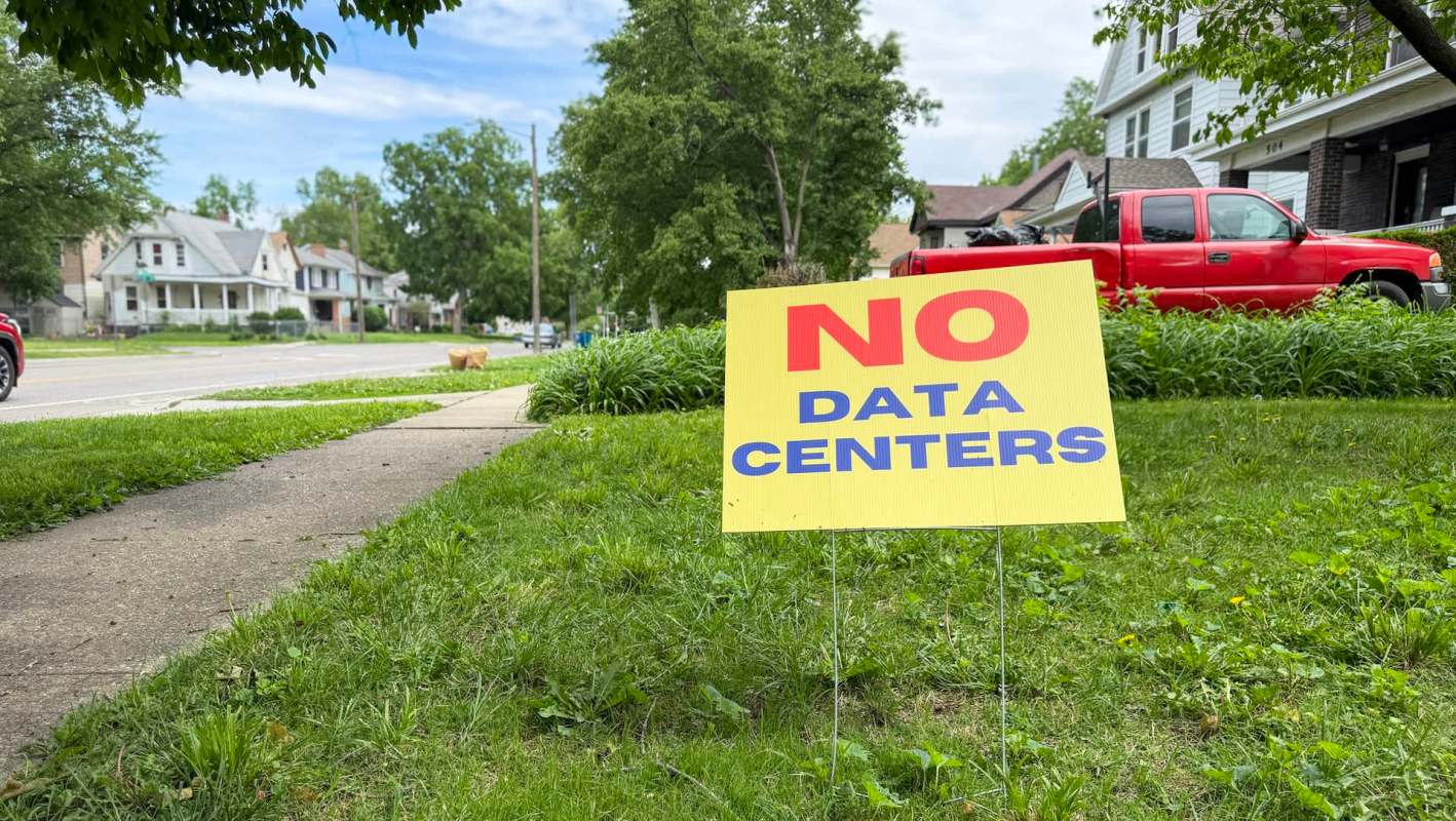 A yellow sign in a yard reads "NO DATA CENTERS."