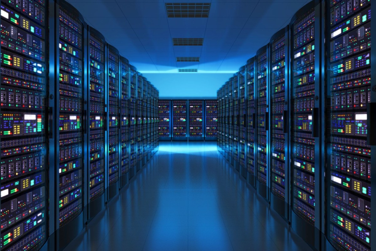 A modern data center aisle lined with tall server racks illuminated by colored LED lights.