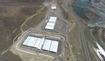 An aerial view of a large industrial facility with white-roofed buildings.