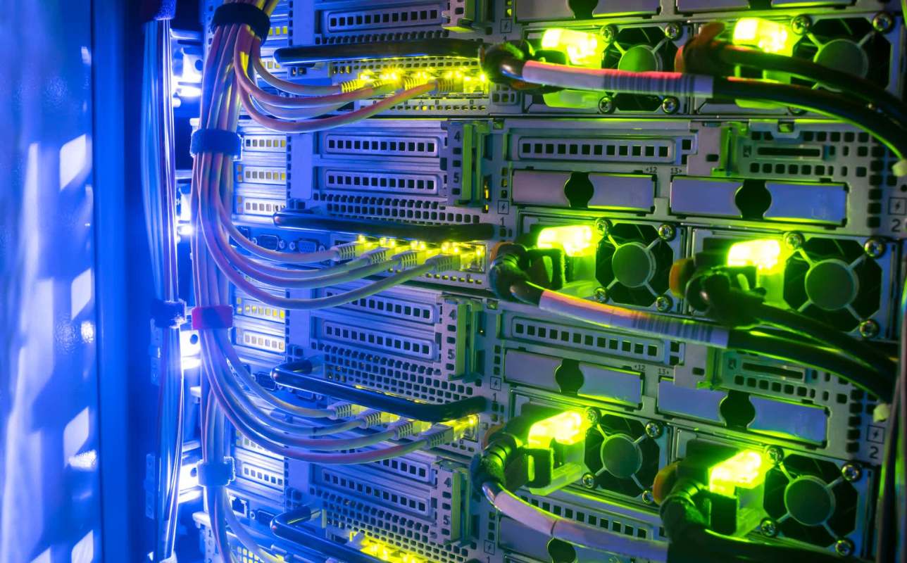 A close-up view of illuminated server racks with colorful cables and glowing indicators.