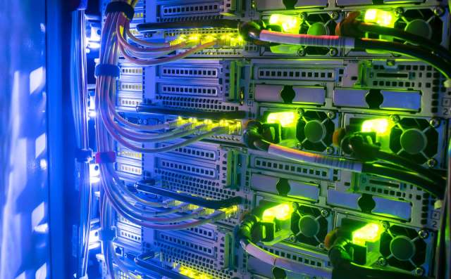 A close-up view of illuminated server racks with colorful cables and glowing indicators.