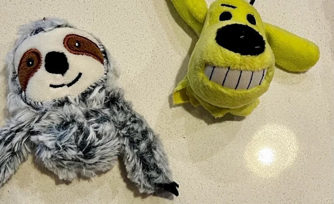 A gray sloth plush toy and a yellow dog plush toy.