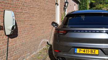 A Porsche EV charging at a wall-mounted charger.